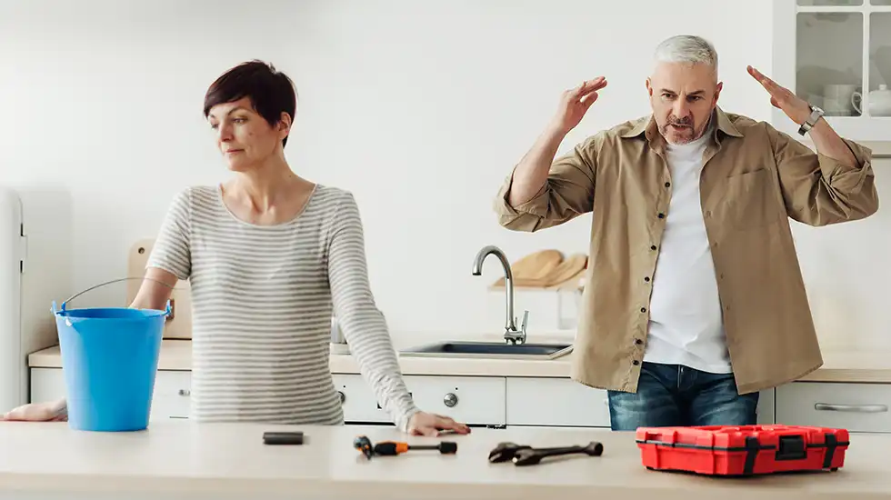 Man and woman arguing over a bad DIY plumbing job